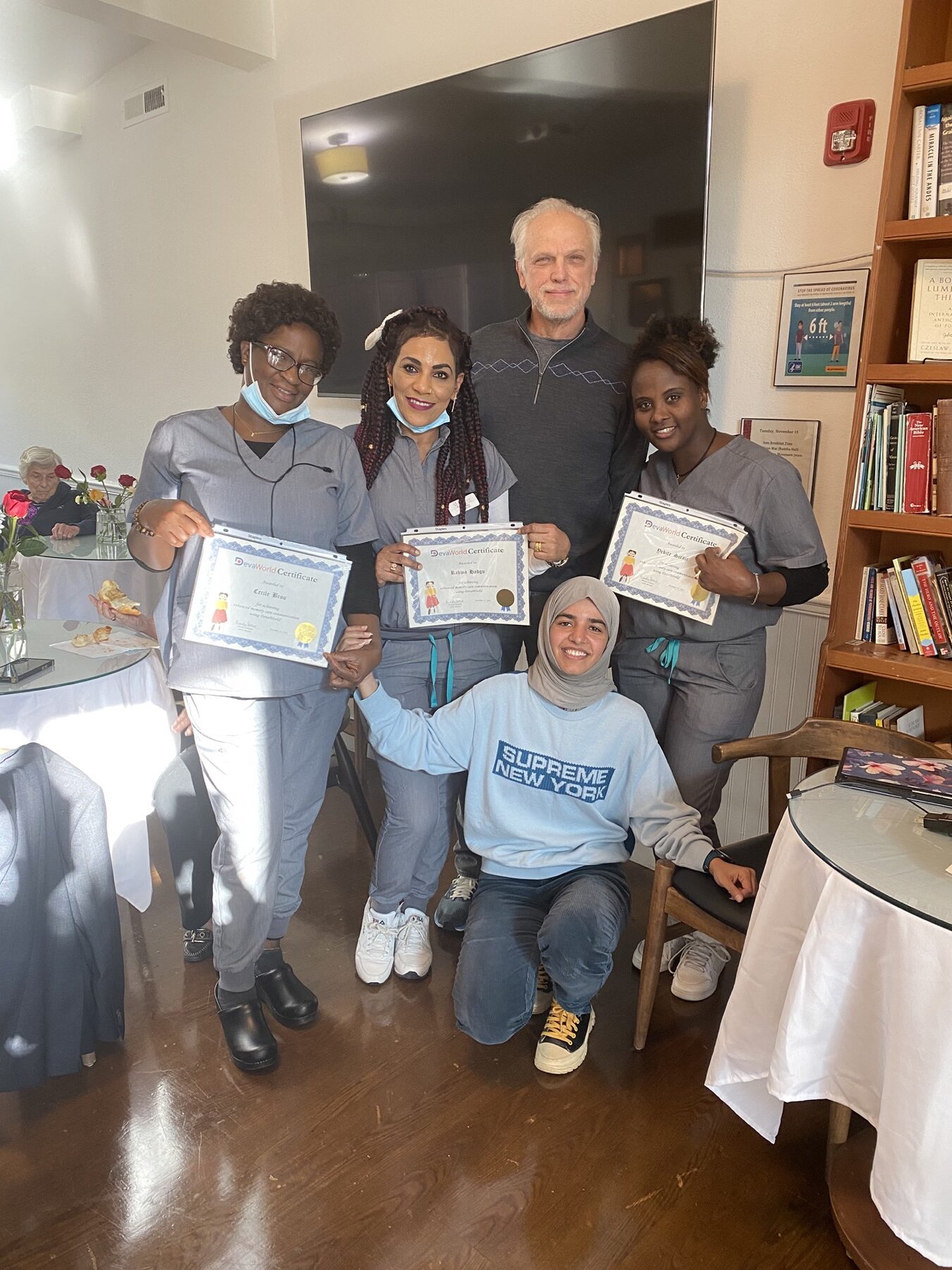 Care staff holding their DevaWorld certificates alongside the Mentia team