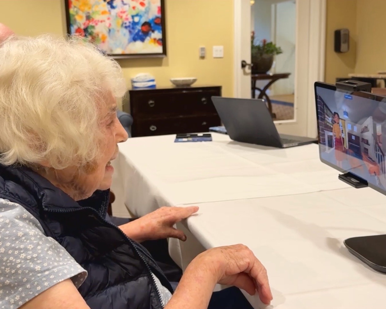 A resident at Creekview memory care chatting with MentiaCompanion on a tablet