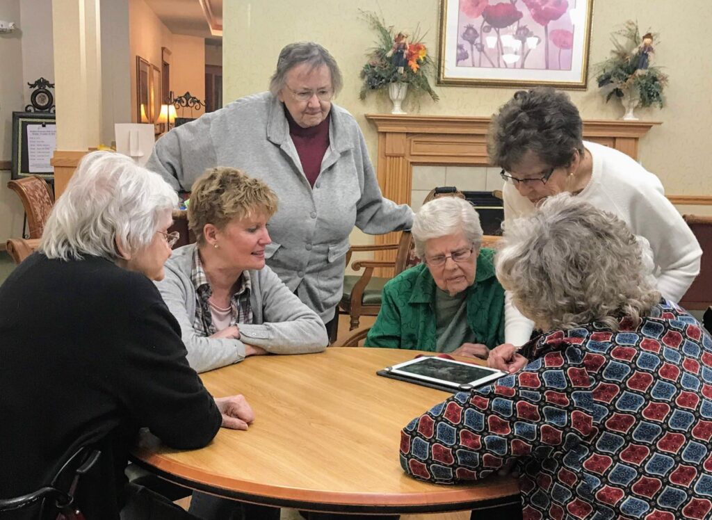 Residents gathered around a tablet during a Mentia session