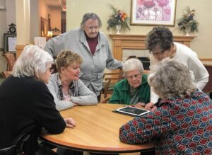 Residents gathered around a tablet during a Mentia session